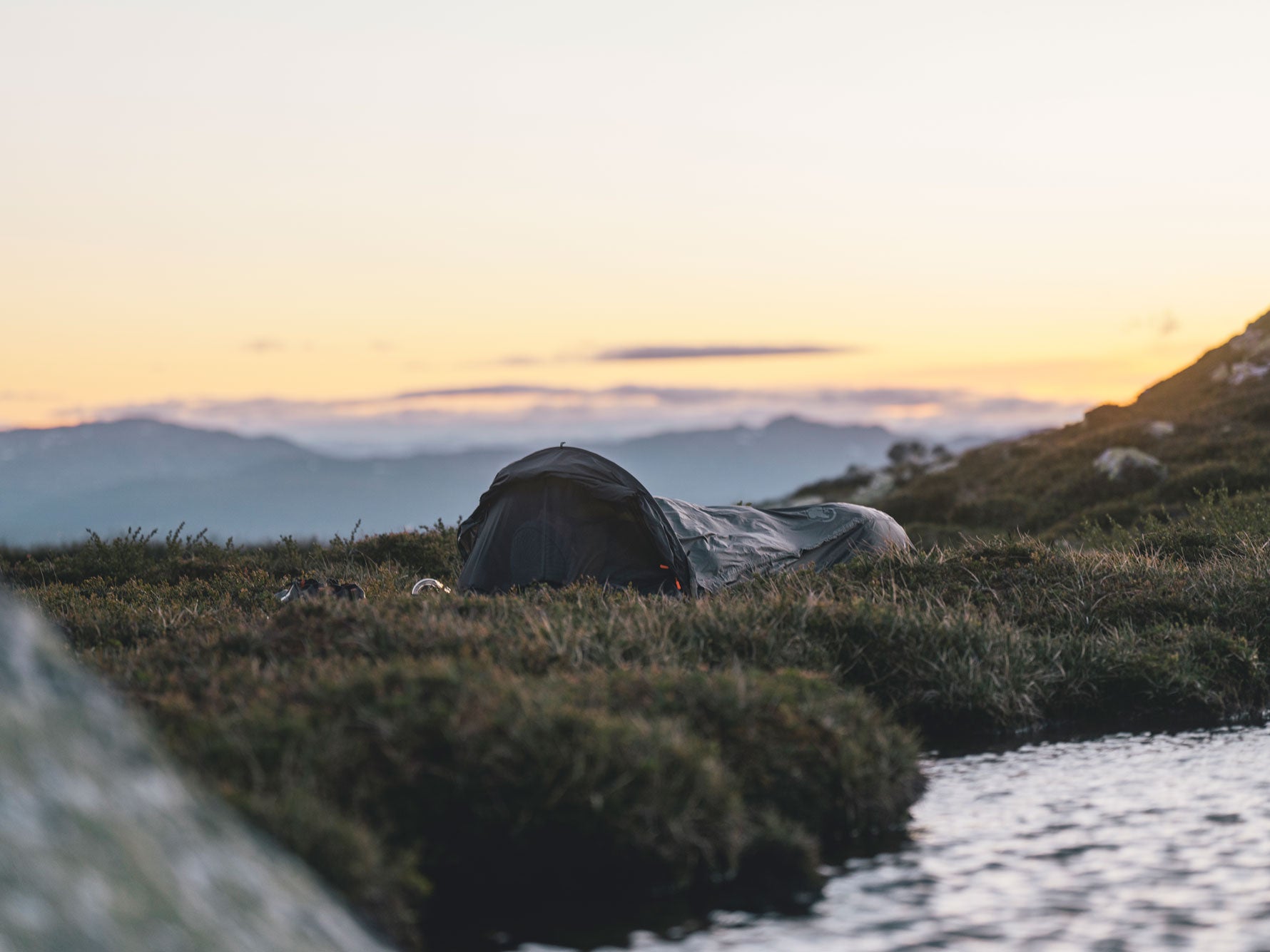 Bivi on grass next to a stream