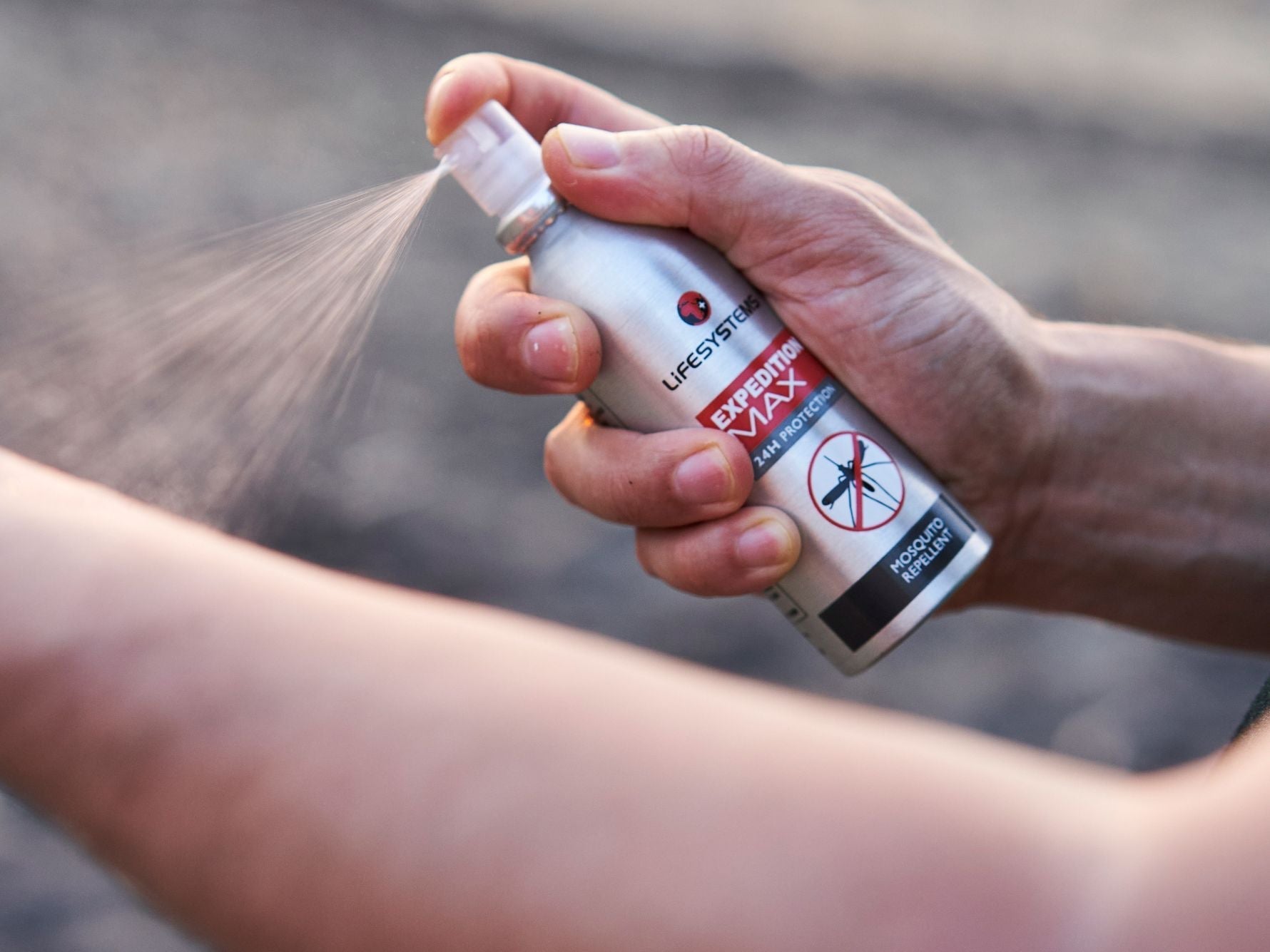 Lifesystems Expedition MAX DEET Insect Repellent being sprayed onto an arm