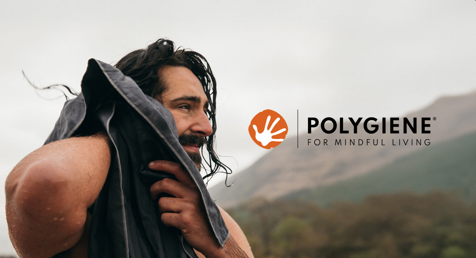 Man drying his hair with a Lifeventure HydroFibre towel treated with Polygiene technology.