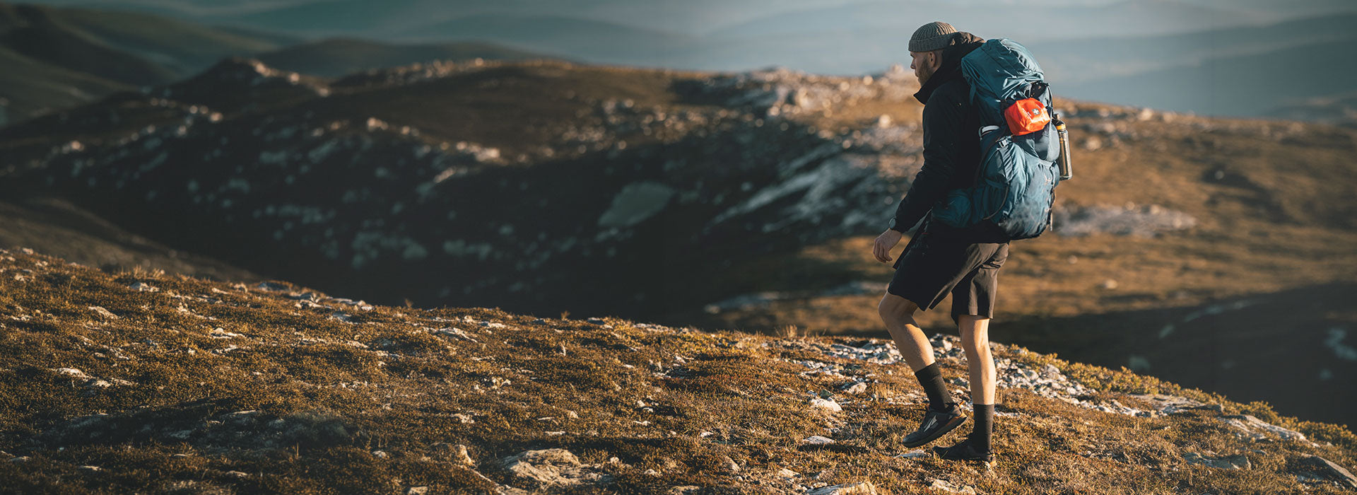 Man hiking with lifesystems first aid kit and water filter bottle