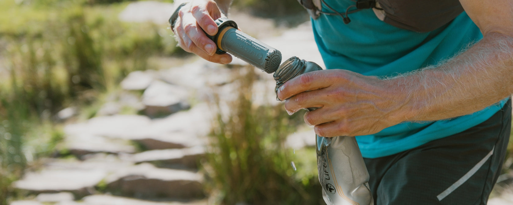 Lifesystems Water Filter Purifier Cartridge being attached to soft flask.